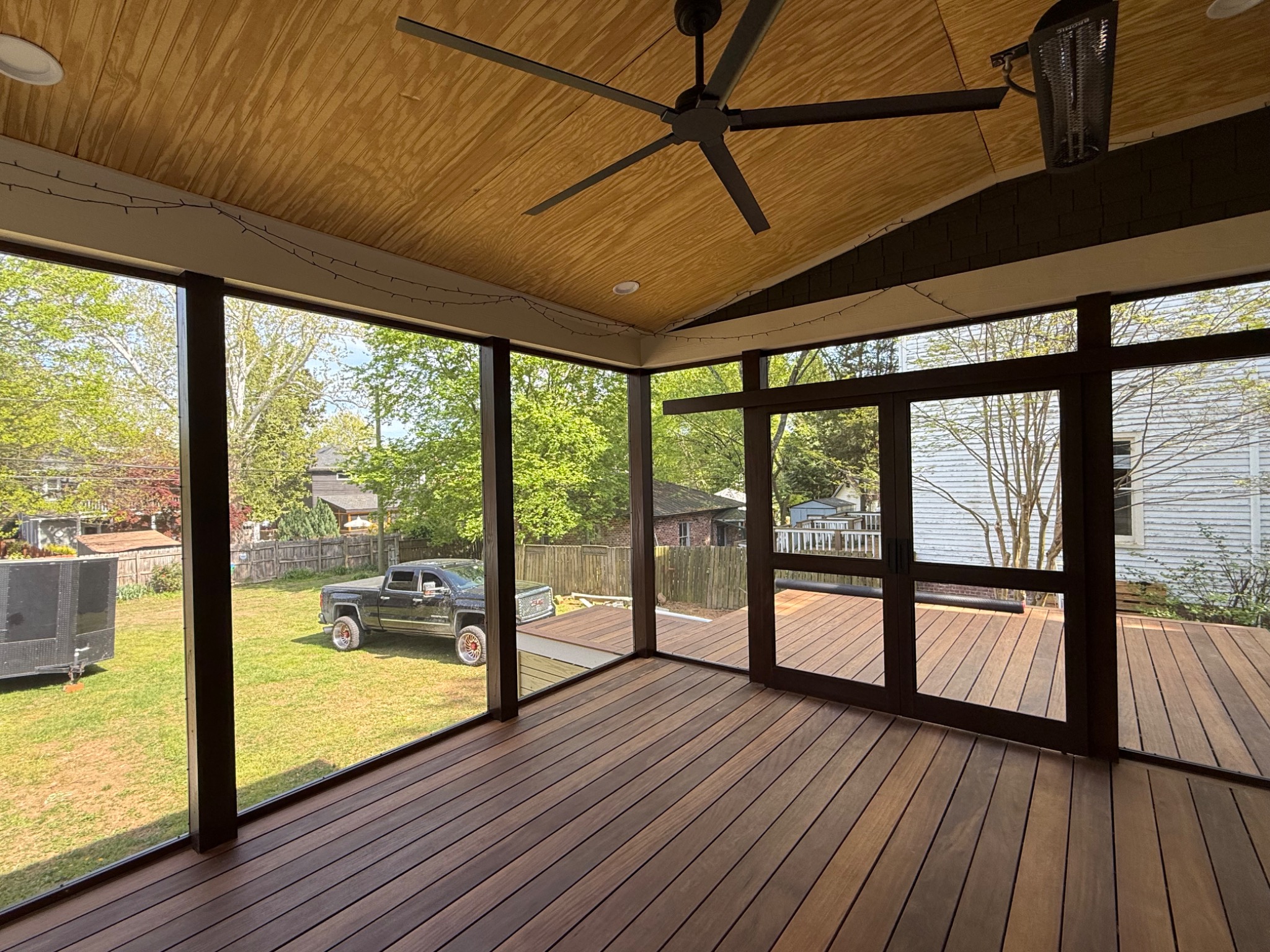 Screened porch interior with full height screens and ceiling fan