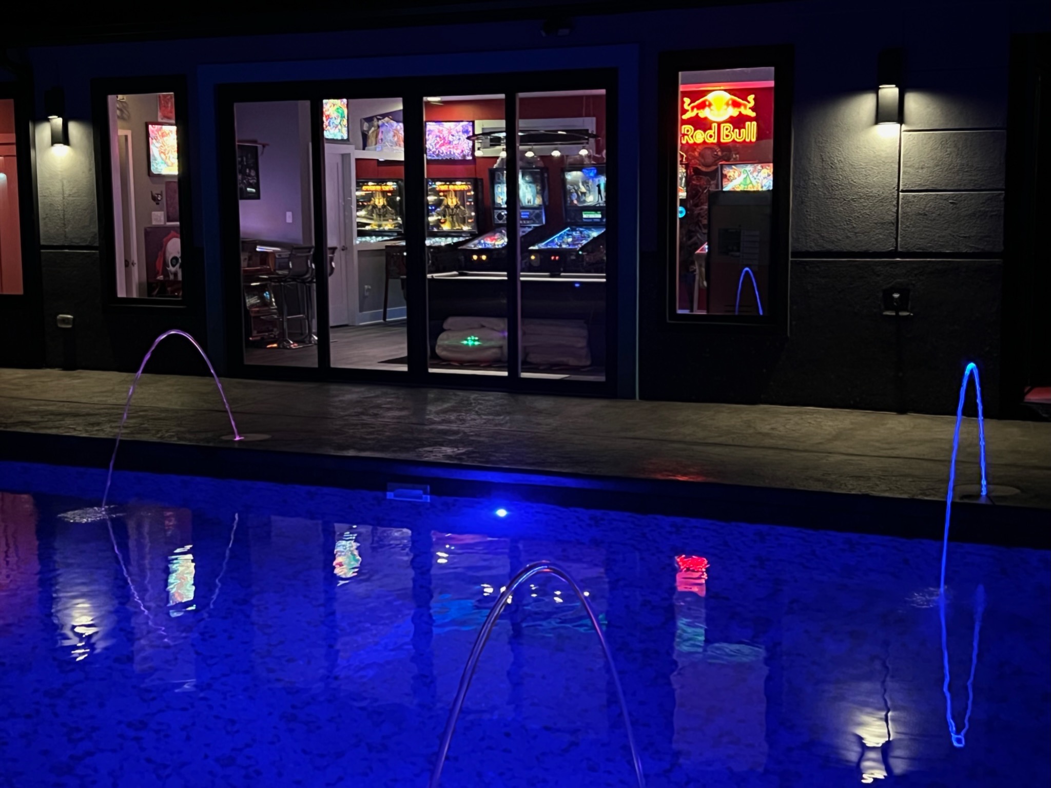 Courtyard pool at night with water features and interior views