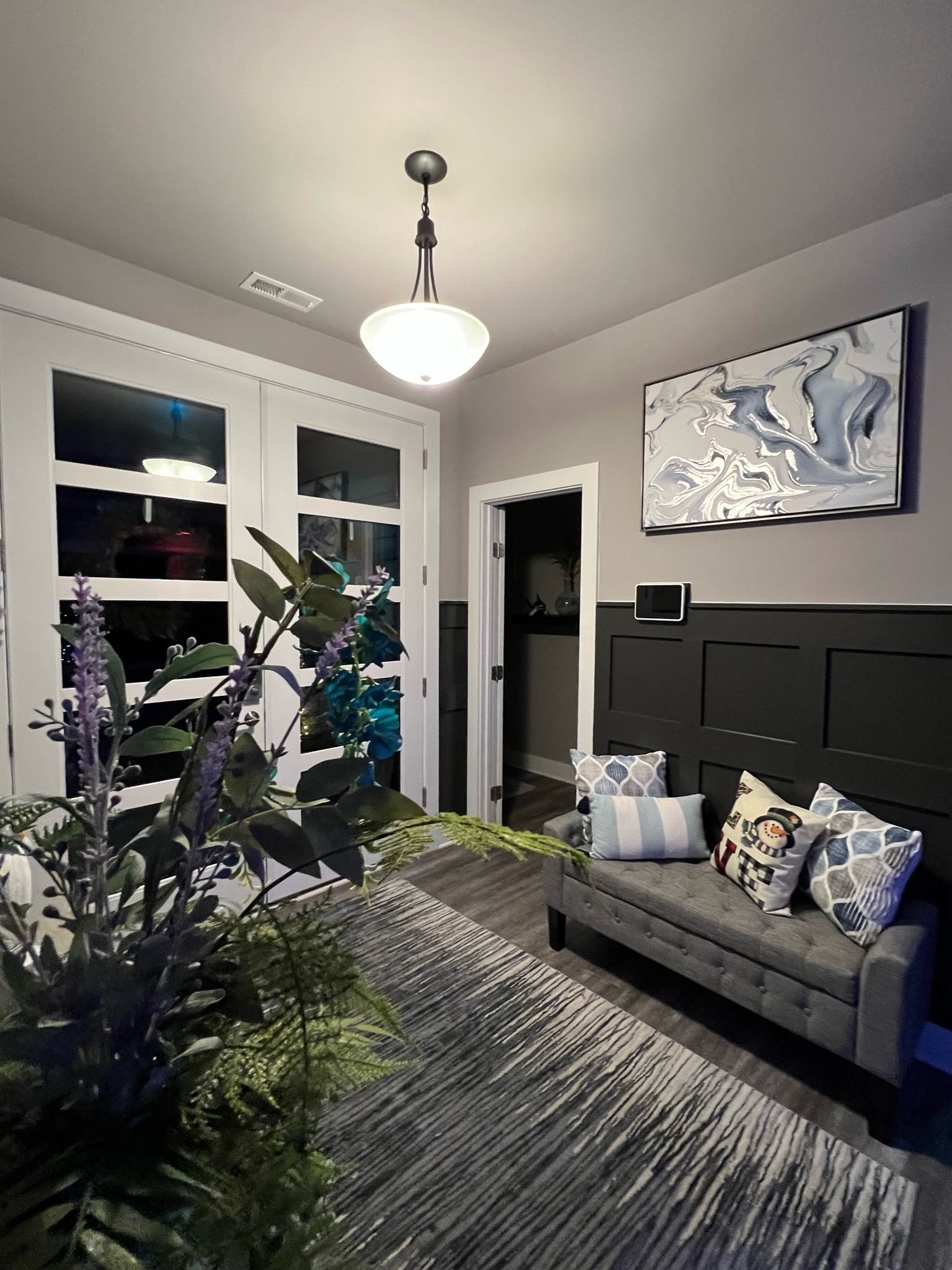 Finished foyer with custom wall paneling and modern doors