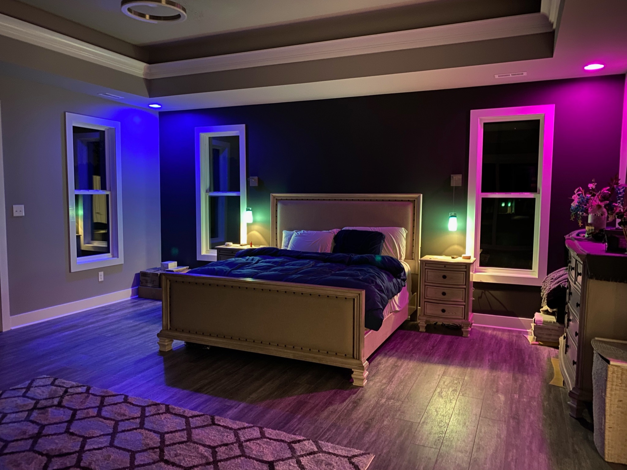 Finished primary bedroom with tray ceiling and custom accent lighting