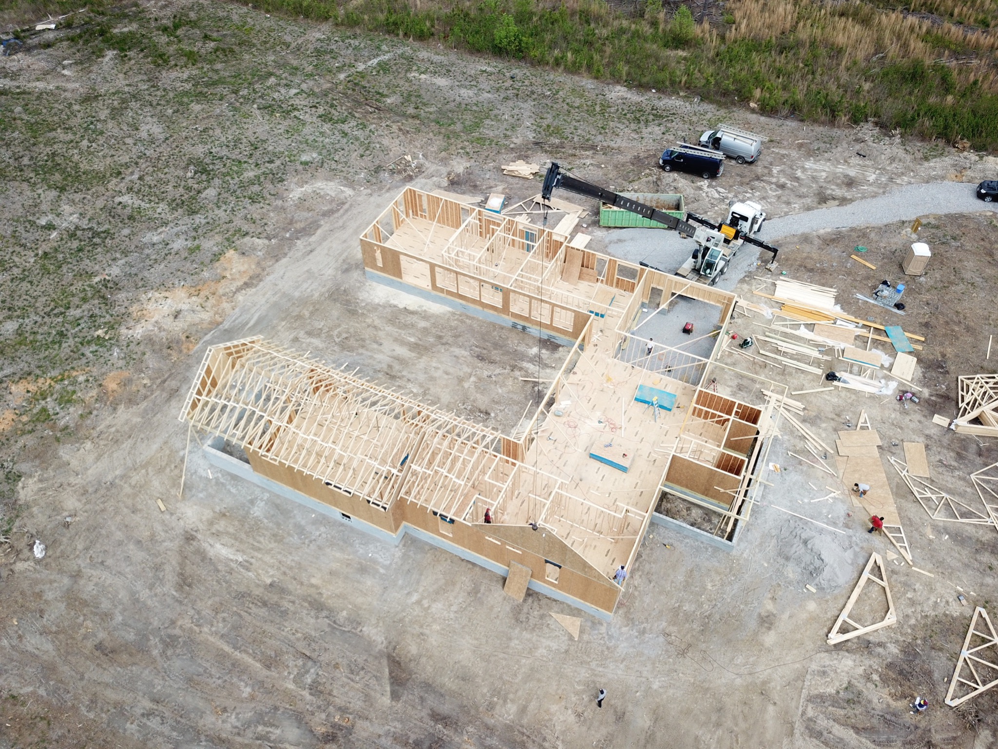 Crane setting roof trusses on custom home