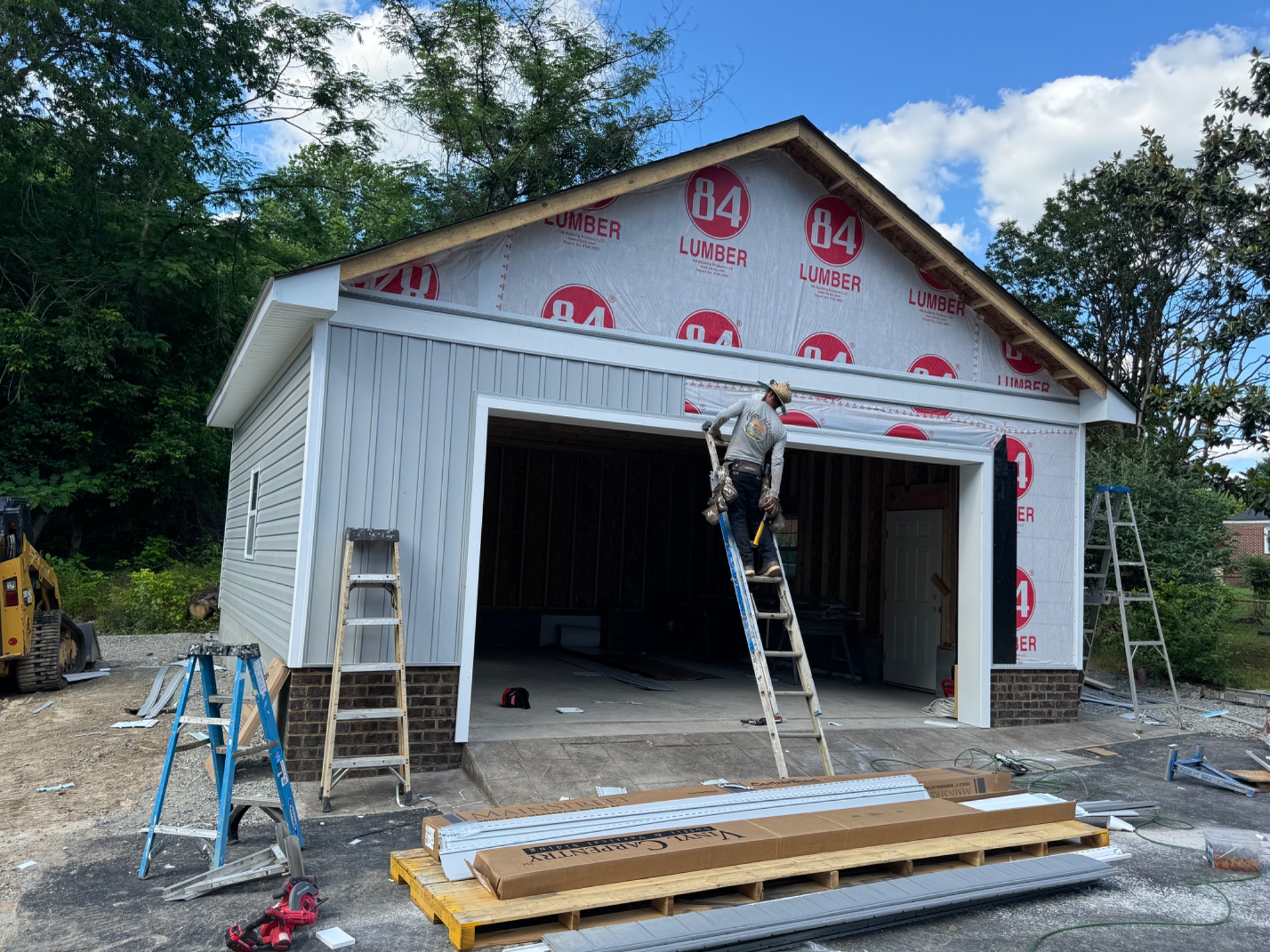 Crew installing siding and trim on detached garage