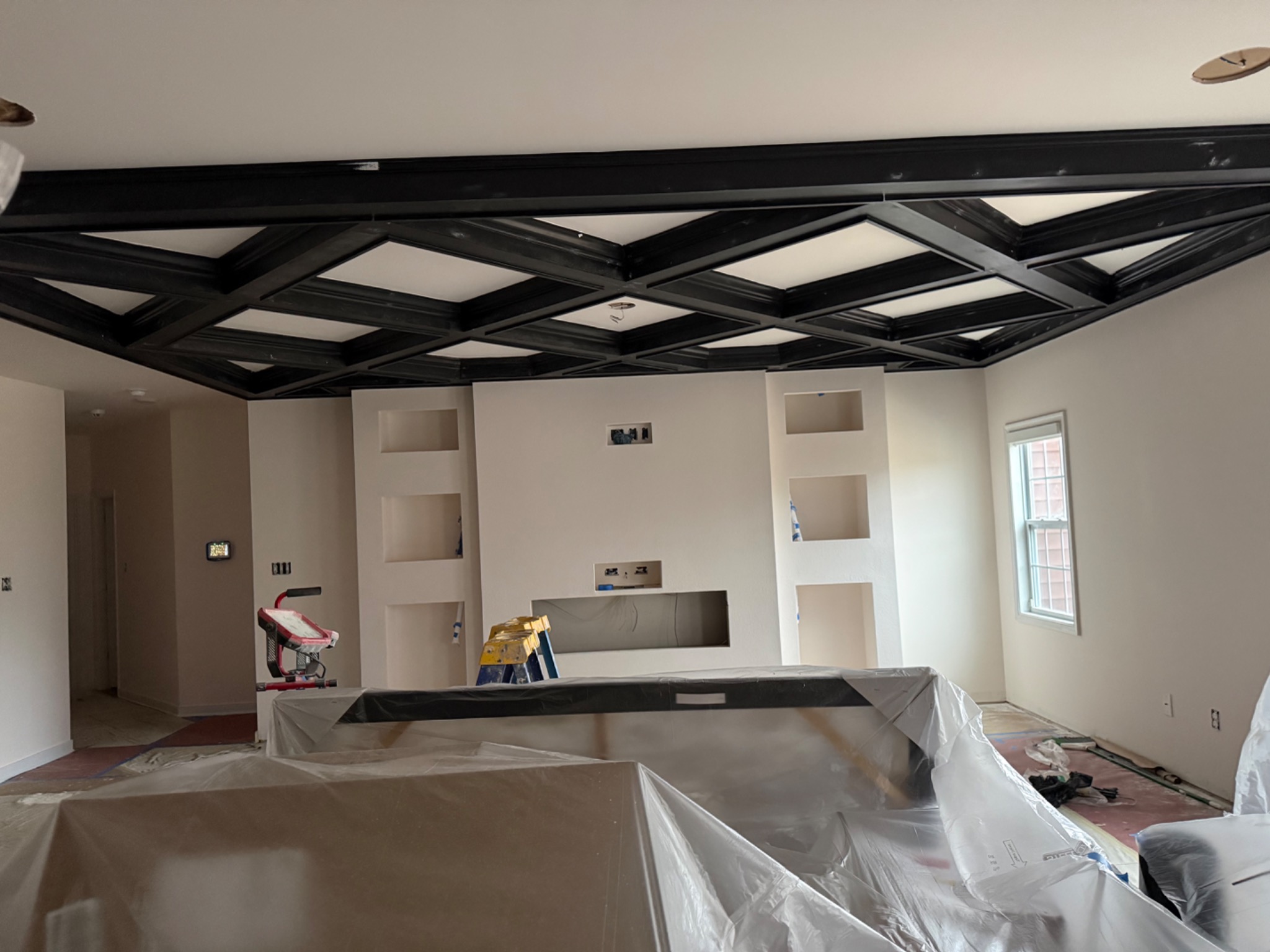 Coffered ceiling painted black with white inset panels