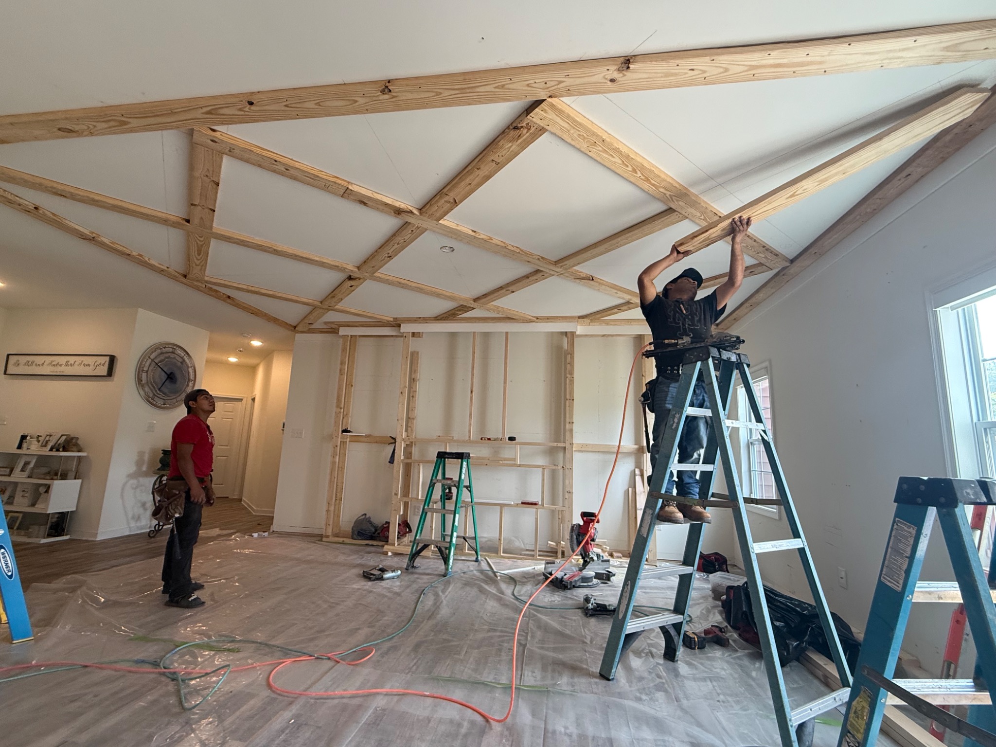 Carpenters installing the wood framework for the custom coffered ceiling