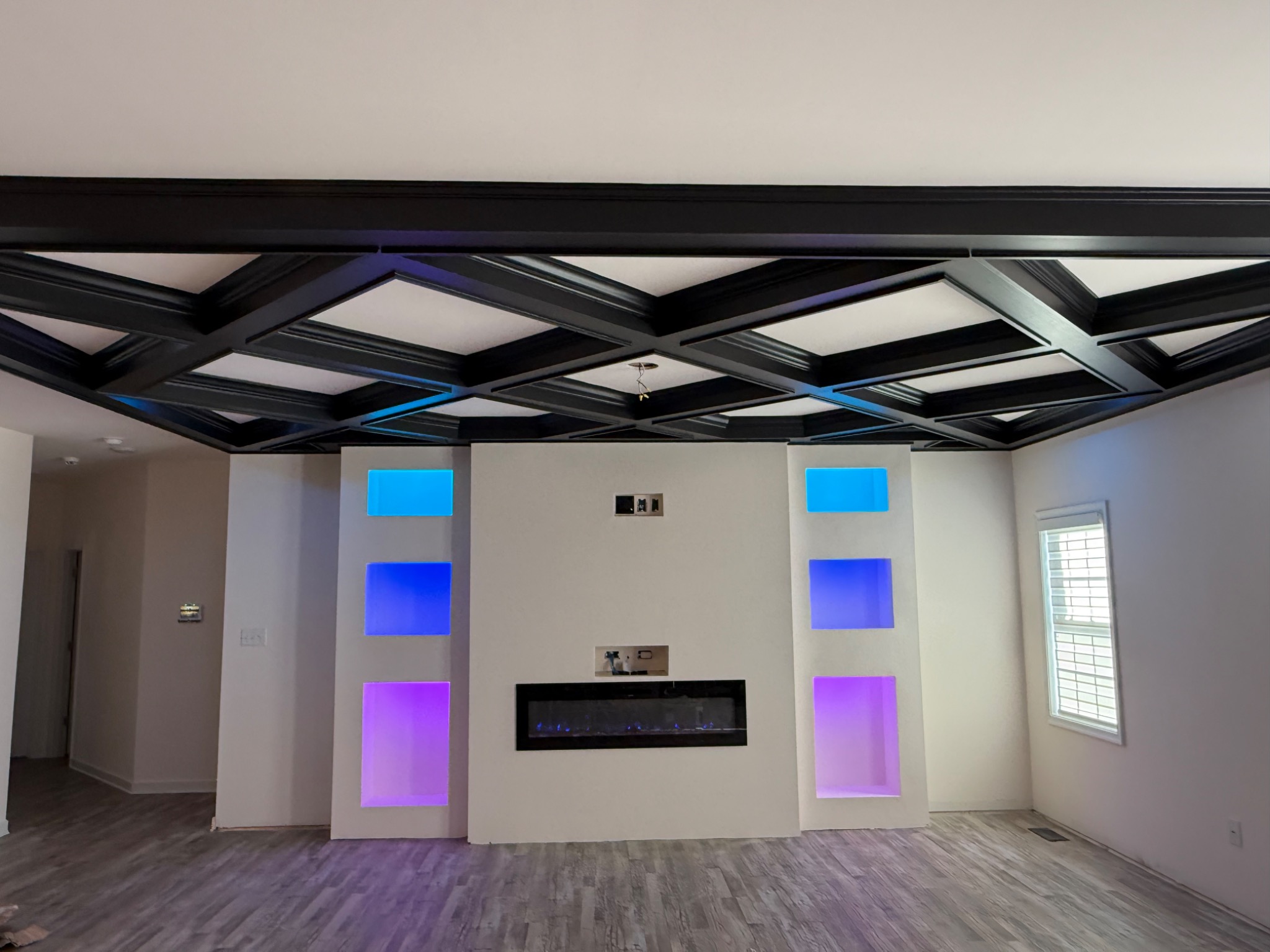 Completed entertainment wall with electric fireplace and illuminated color-changing display niches