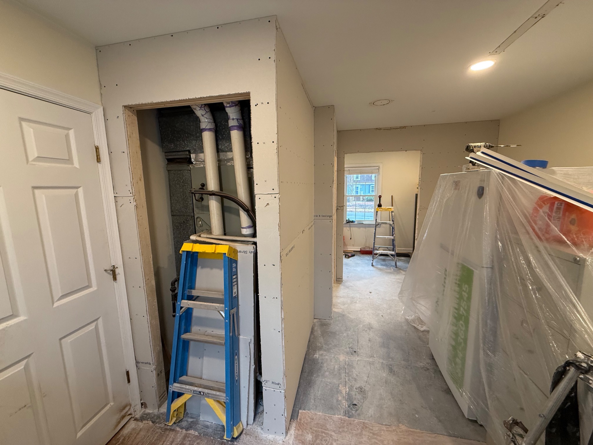New drywall partitions being built around existing HVAC equipment