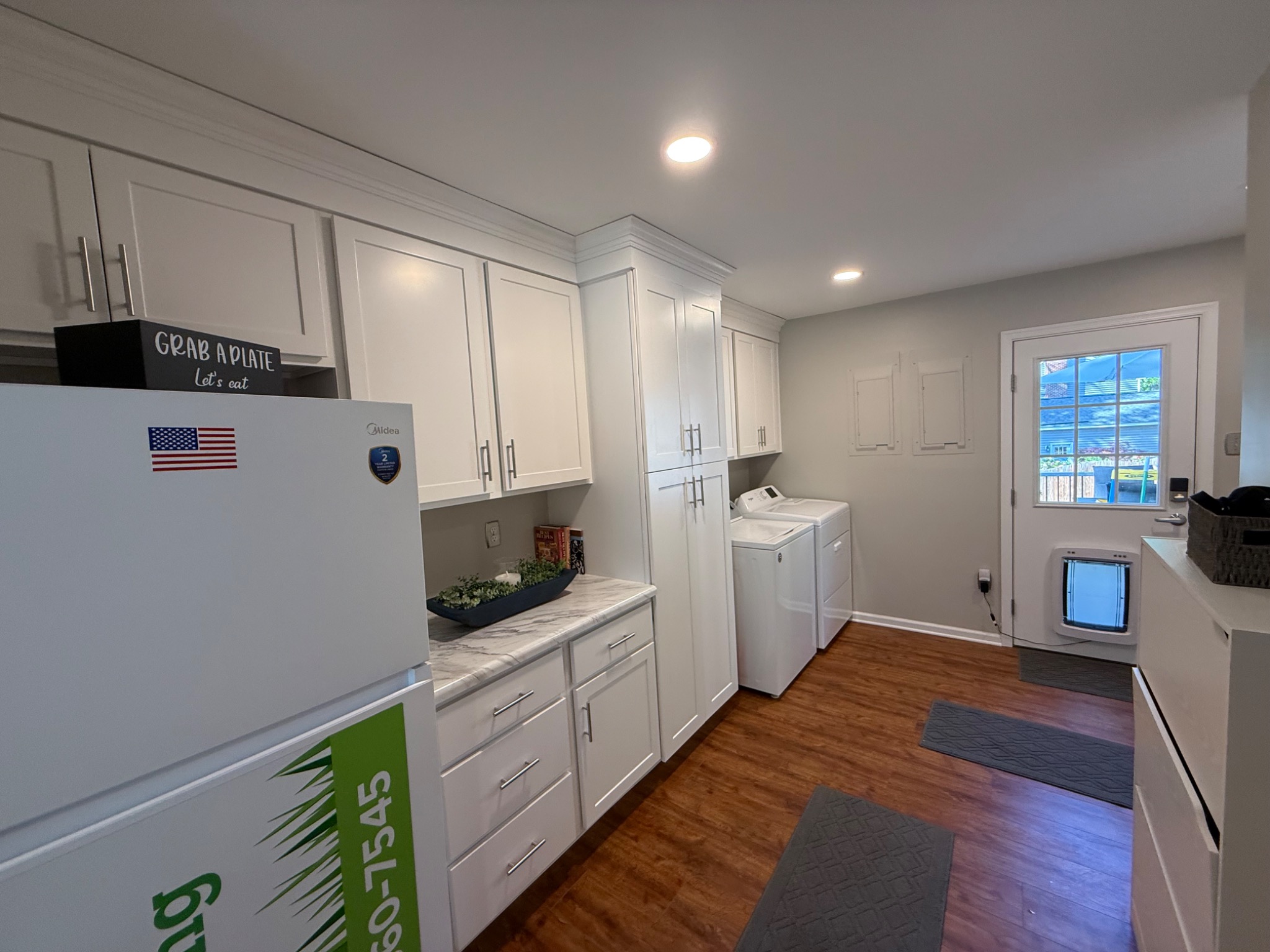 Completed office and laundry conversion showing new cabinetry, flooring, and lighting