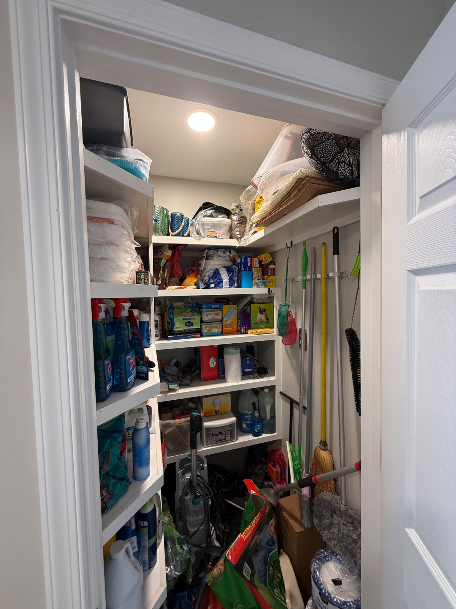 Finished storage closet with wraparound shelving and recessed lighting