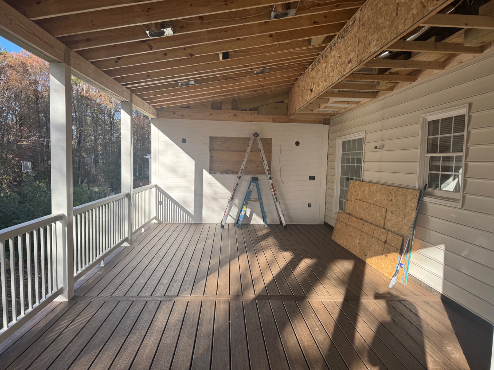 Composite decking, railings, and unfinished porch ceiling during construction
