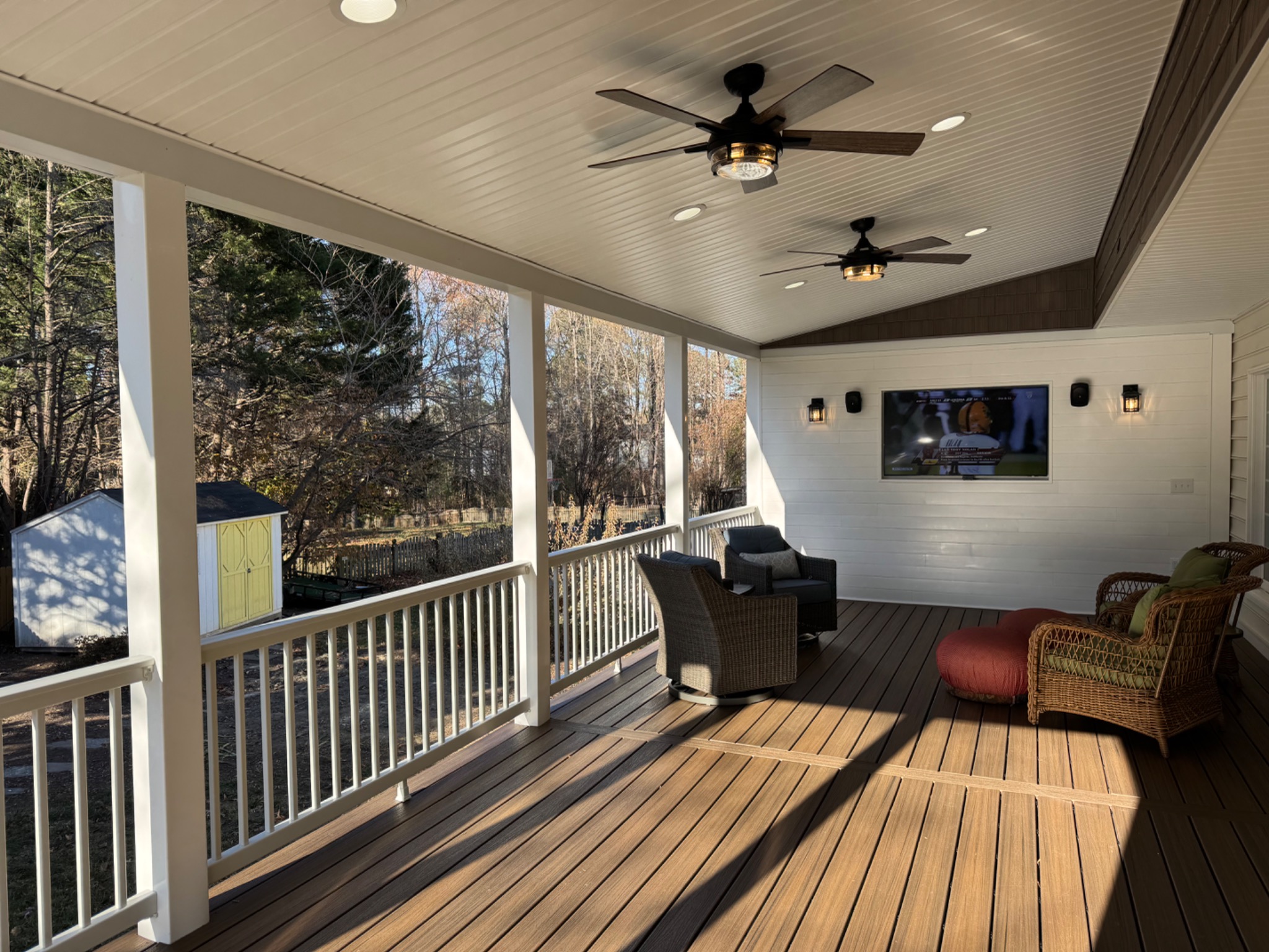 Completed 520 square foot screened porch with composite decking, ceiling fans, television, and outdoor seating