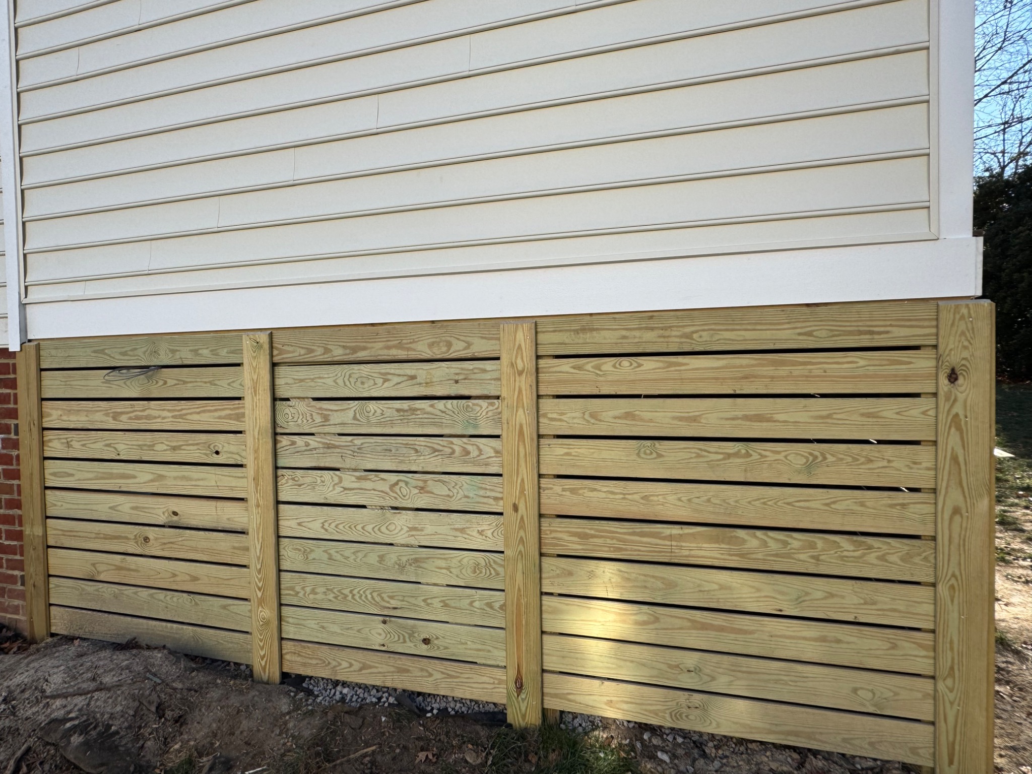 Finished horizontal wood skirting beneath screened porch