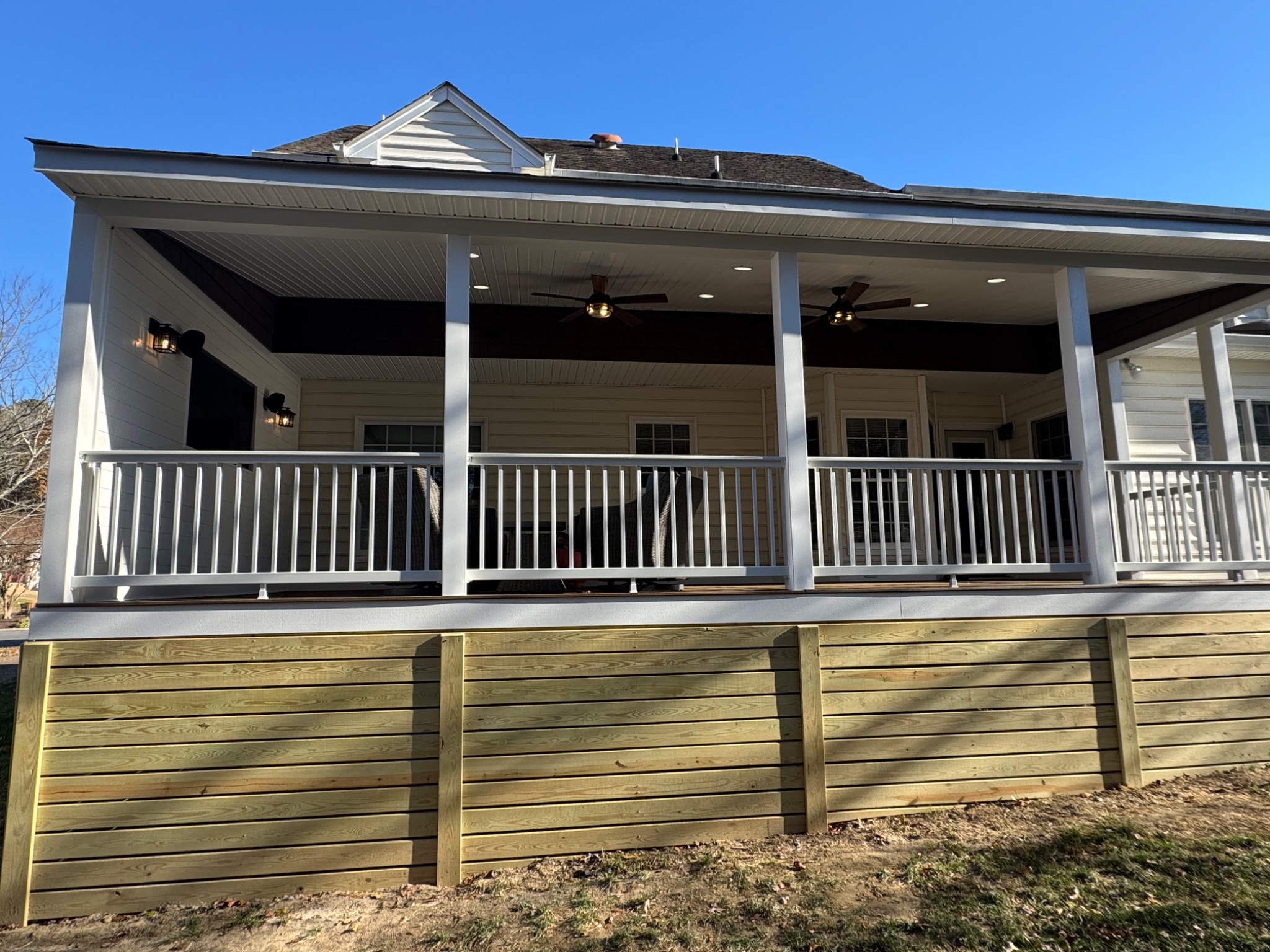 Custom horizontal wood skirting with access door beneath screened porch