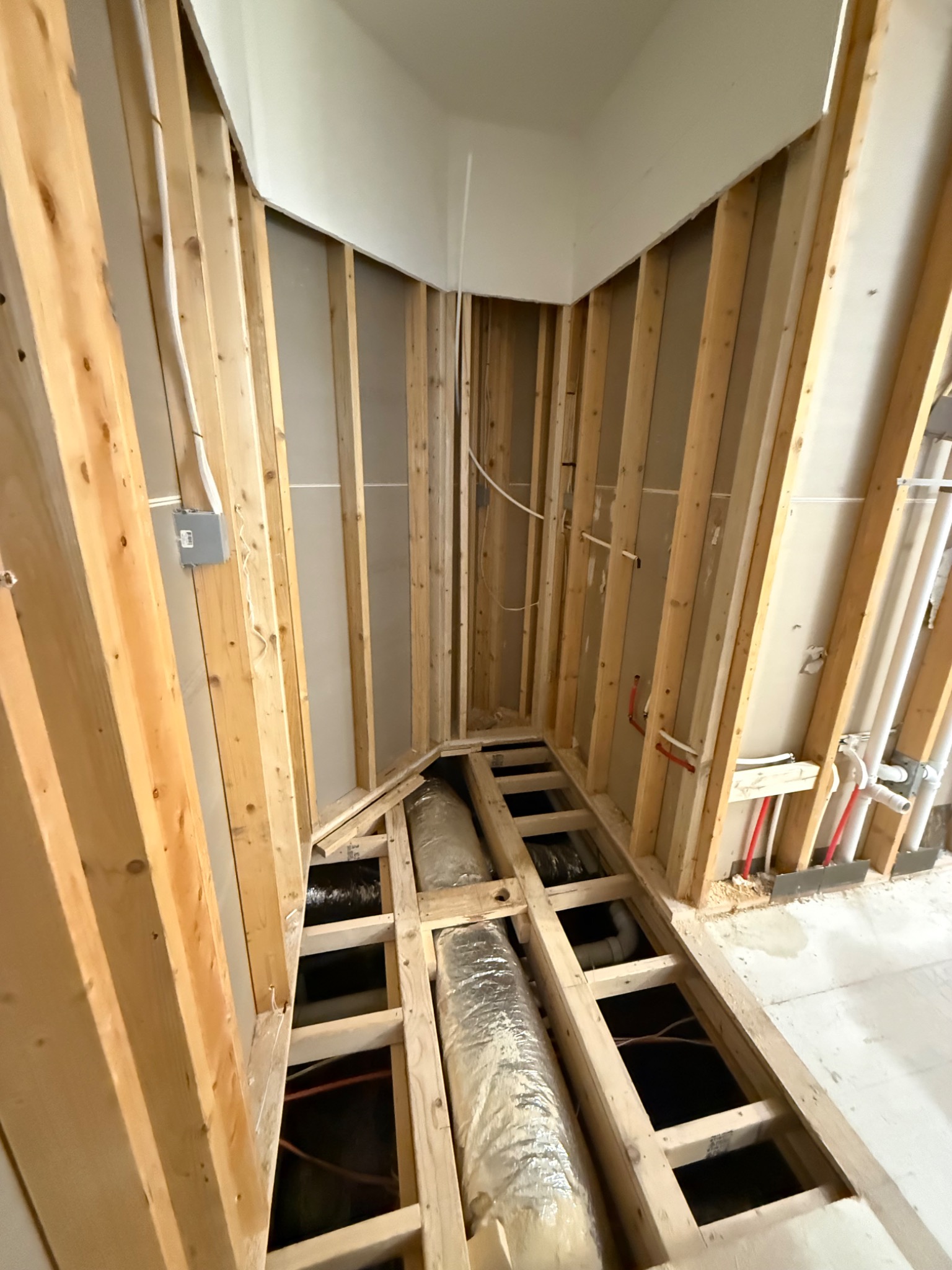 Bathroom floor opened and reframed for plumbing and shower work