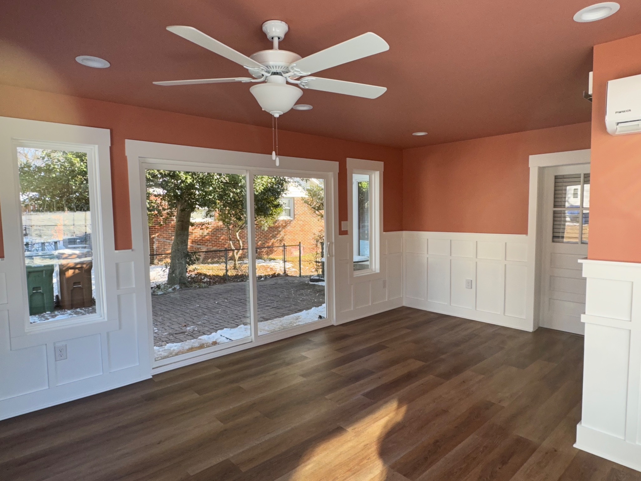 Finished sunroom with large sliding glass door and custom wall trim