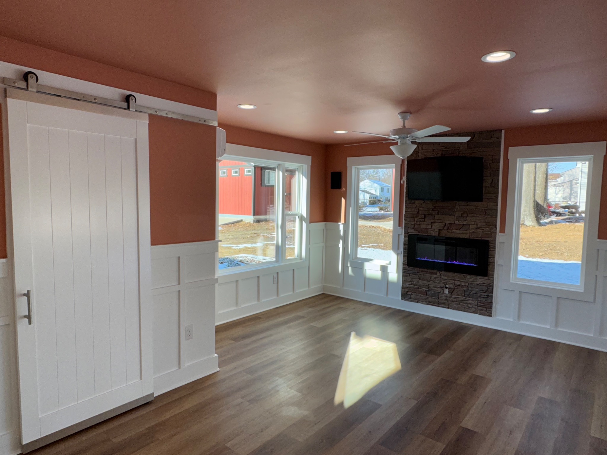Completed sunroom looking toward stone fireplace and windows