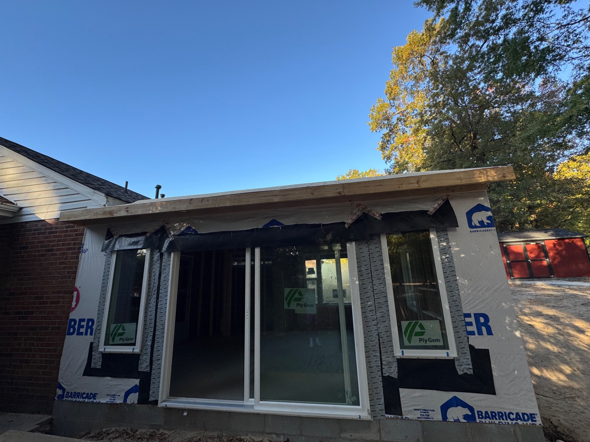 Sunroom addition wrapped and weatherproofed with windows installed